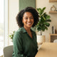 A diverse woman smiling confidently in a bright, modern interior setting, representing a happy and satisfied customer.